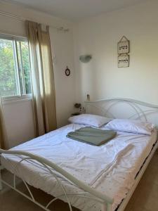 a white bed in a bedroom with a window at נופש איילה in Bnei Yehuda