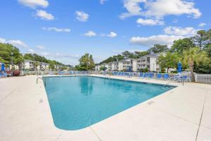 a swimming pool at a resort with blue chairs at Stunning 3 Bedroom Condo-Recently Renovated-Fairways Unit D in Myrtle Beach