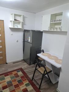 a kitchen with a table and a refrigerator at Ali Relax Home Apartment in Roman