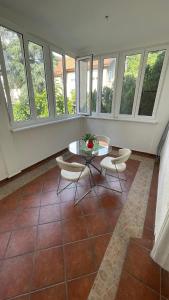 Zimmer mit einem Tisch, Stühlen und Fenstern in der Unterkunft Filip Luxury Suite in Belgrad