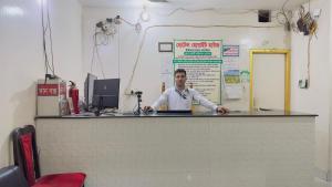 a man standing behind a counter in a room at Hotel White House International (Near Dhaka Medical) in Dhaka