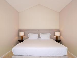 1 dormitorio con 1 cama blanca grande y 2 lámparas en Quinta da Casa Grande en Ponta Delgada