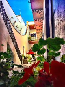 um edifício com uma ponte e uma planta com flores vermelhas em El Serafin Hotel Boutique em Querétaro