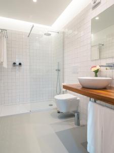 a white bathroom with a sink and a toilet at Quinta da Casa Grande in Ponta Delgada