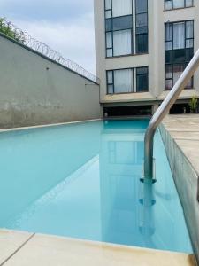 a swimming pool in front of a building at Gem by T in Rongai with a pool in Ongata Rongai 