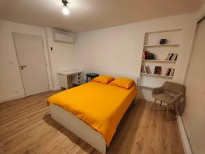 una camera con letto giallo e sedia di RDC T4 Maison proche Aéroport a Saint-Laurent-de-Mure