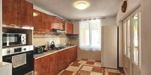 a kitchen with wooden cabinets and a white refrigerator at Hillside in Oradea