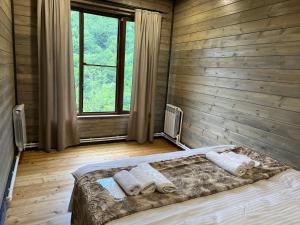 ein Schlafzimmer mit einem Bett mit Kissen und einem Fenster in der Unterkunft Balkonchik GuestHouse in Dilidschan