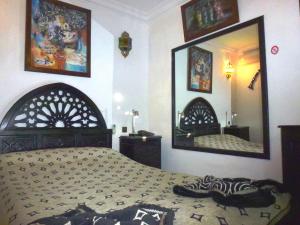 1 dormitorio con cama y espejo grande en Ryad Laârouss en Marrakech