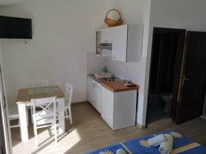 una pequeña cocina con una mesa pequeña, una mesa, una mesa y una silla en Apartments Martin, en Primošten