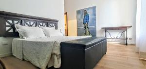 a bedroom with a large bed with a leather couch at Appartamento I Cipressi in Castiglione del Lago
