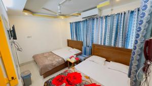 two beds in a room with red roses at Hotel Panthapath Dhaka in Dhaka