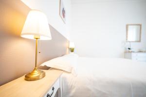 a lamp on a table next to a bed at Villa Vichéia - Appartement 2 in Vichy