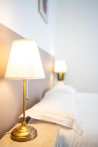 a lamp on a table next to a bed at Villa Vichéia - Appartement 2 in Vichy