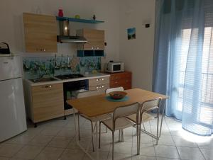a kitchen with a table and chairs and a refrigerator at millennium holiday in Castellammare del Golfo
