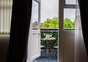 una porta aperta che conduce a un patio con tavolo di Central Birmingham Apartment W/Balcony a Birmingham