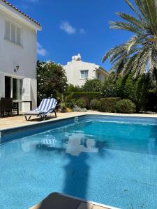 una piscina con una silla junto a una casa en Coral Bay Villa Daniella, en Bahía de Coral