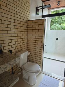 a bathroom with a toilet and a glass shower at Chalé Premium no Centro da Vila in Itaúnas +21 photos