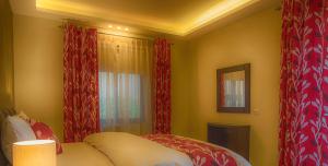 1 dormitorio con cortinas rojas y 1 cama en Shams Alweibdeh Hotel Apartments en Amán
