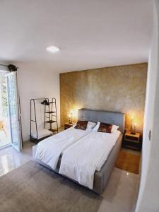 sypialnia z dużym białym łóżkiem i krzesłem w obiekcie Apartmani kike w Makarskiej