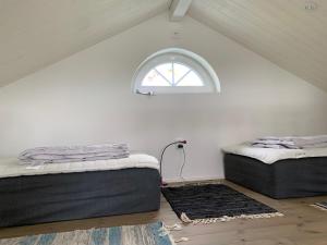zwei Betten in einem Zimmer mit Fenster in der Unterkunft Hassels hus in Vikingstad