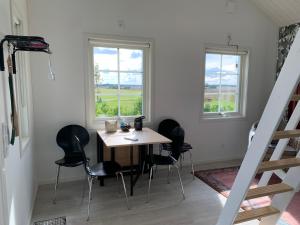 ein Tisch und Stühle in einem Zimmer mit zwei Fenstern in der Unterkunft Hassels hus in Vikingstad