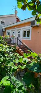 une maison avec des plantes vertes devant elle dans l'établissement Apartmani Milicevic, à Igalo