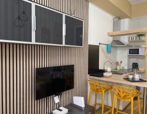 eine Küche mit einer Theke mit zwei Stühlen und einem TV in der Unterkunft Work Room - kasasbenas in Benasque