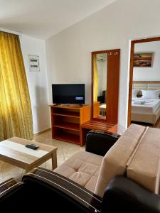 uma sala de estar com um sofá e uma televisão em Apartments Rudaj em Ulcinj
