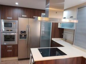 a kitchen with stainless steel appliances and wooden cabinets at Apartamento 3 dormitorios in San Vicente del Raspeig