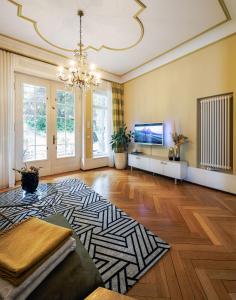 a large living room with a chandelier and a television at Villa Nußbaumer - Business-und Ferienwohnung in bester Lage in Arnstadt