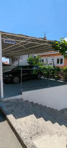 un concessionnaire automobile avec une voiture garée dans un parking dans l'établissement Apartmani Milicevic, à Igalo