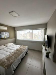 a bedroom with a large bed and a window at Flat Premium Recife - Ilha do leite piscina termica in Recife