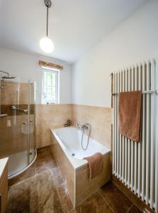 bagno con vasca e doccia in vetro di Villa Nußbaumer - Business-und Ferienwohnung in bester Lage ad Arnstadt