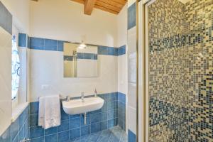 a blue tiled bathroom with a sink and a shower at Casa Vacanze Villa Liotta in Agropoli +40 photos