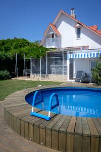 a swimming pool with a wooden deck next to a house at Будинок біля моря з басейном Одеса для 7 гостей - 3 спальні in Odesa