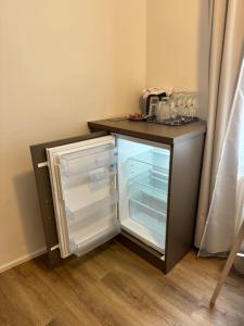 einem Kühlschrank mit Tür neben einer Theke in der Unterkunft Apartmánový Dům Centrum in Brünn