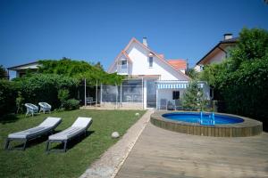 un patio trasero con piscina, bancos y una casa en Будинок біля моря з басейном Одеса для 7 гостей - 3 спальні en Odesa