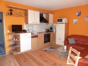 eine Küche mit einem Sofa und einem Tisch in einem Zimmer in der Unterkunft Ferienwohnung Klabautermann in Putbus