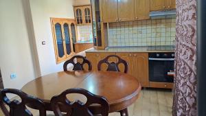 a kitchen with a wooden table and chairs at Dream Home in Pogradec