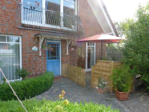 a brick house with a blue door and an umbrella at Ferienwohnung Klabautermann in Putbus +7 photos