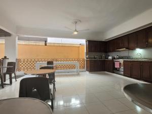 a kitchen with wooden cabinets and tables and chairs at Drake Bolivar Santo Domingo in Santo Domingo