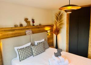 a bed with a teddy bear sitting on top of it at Chalet Apartment Les Balcons Enchantés in Charmey