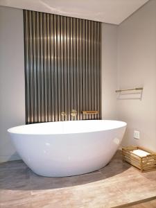 y baño con bañera blanca grande. en HWH Guesthouse Middelburg en Middelburg