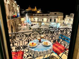 a table with two plates of food on a balcony at Il Pregio in Ostuni