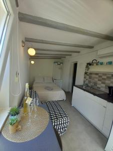 a room with a bed and a table and a kitchen at Apartments Pipi in Pakoštane