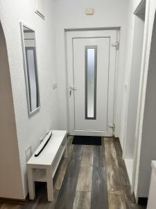 a bathroom with a white door and a bench and mirrors at Apartment Aleja in Sarajevo +10 photos