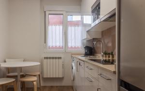 a small kitchen with a table and a window at Apart El Muelle Centro de Ribadesella VUT-3752-AS in Ribadesella +30 photos