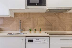 a kitchen with a sink and a microwave at Apart El Muelle Centro de Ribadesella VUT-3752-AS in Ribadesella