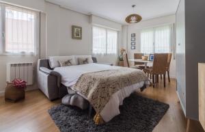 sypialnia z dużym łóżkiem i jadalnią w obiekcie Apart El Muelle Centro de Ribadesella VUT-3752-AS w mieście Ribadesella